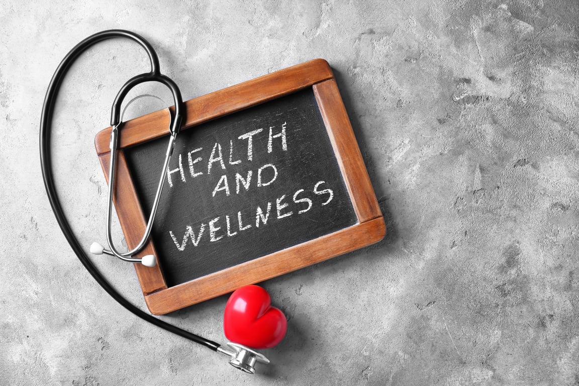 Blackboard with Words "Health and Wellness" and Medical Stethoscope on Grey Background